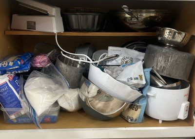 messy disorganized and cluttered lower kitchen cabinet