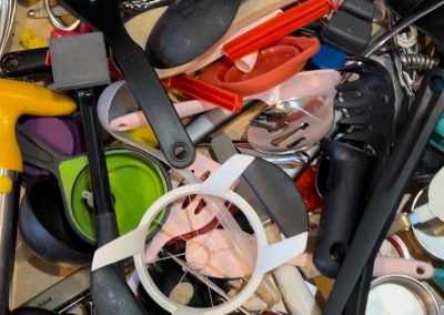 cluttered and messy kitchen utensil drawer