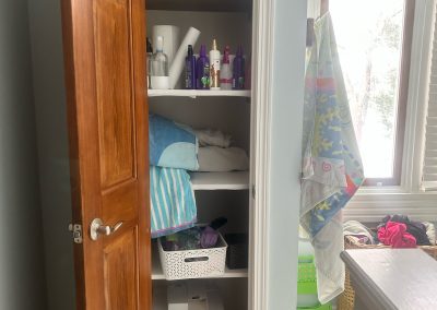bathroom linen closet cluttered and disorganized