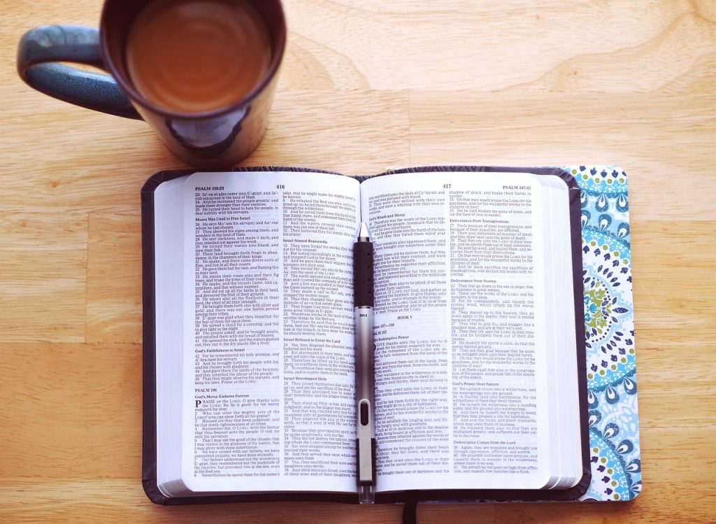 bible on table with pen and coffee