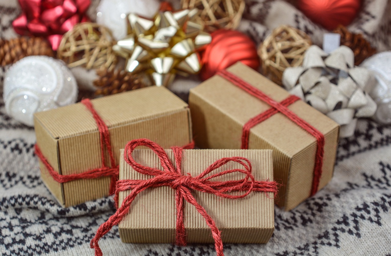 three wrapped Christmas presents surrounded by bows and ornaments